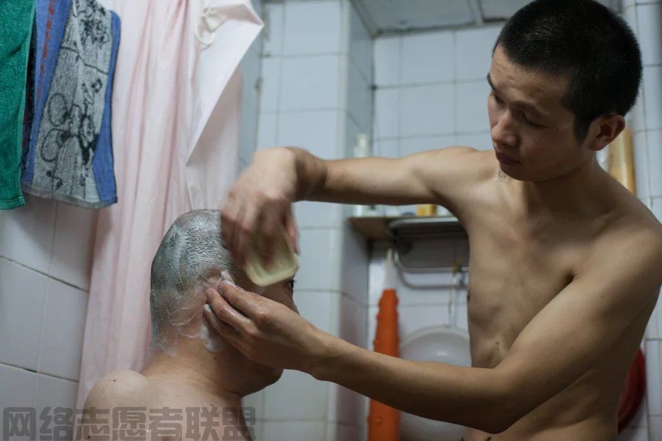 助残--韦腾境为残疾人洗澡.jpg